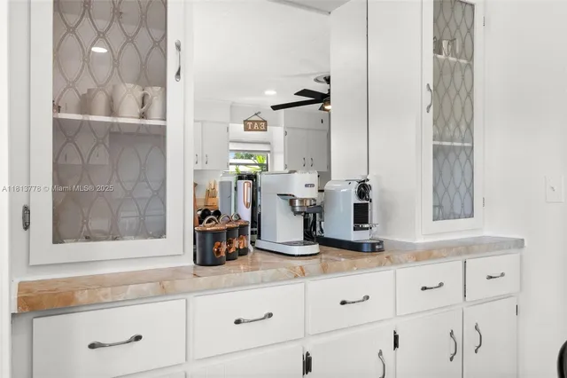 a kitchen with white cabinets and sink