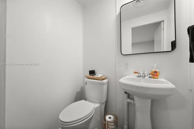 a bathroom with a toilet sink and mirror