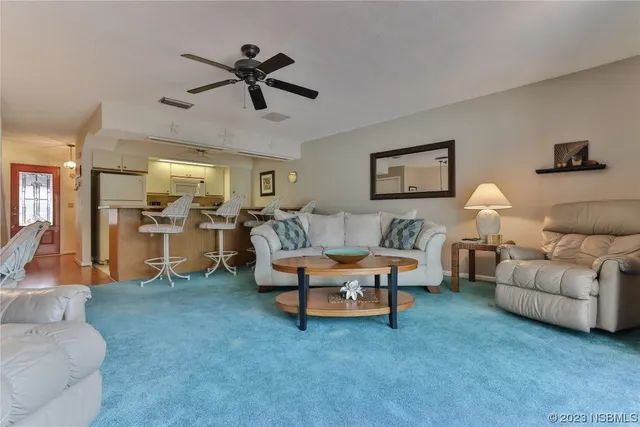 a living room with furniture and a ceiling fan