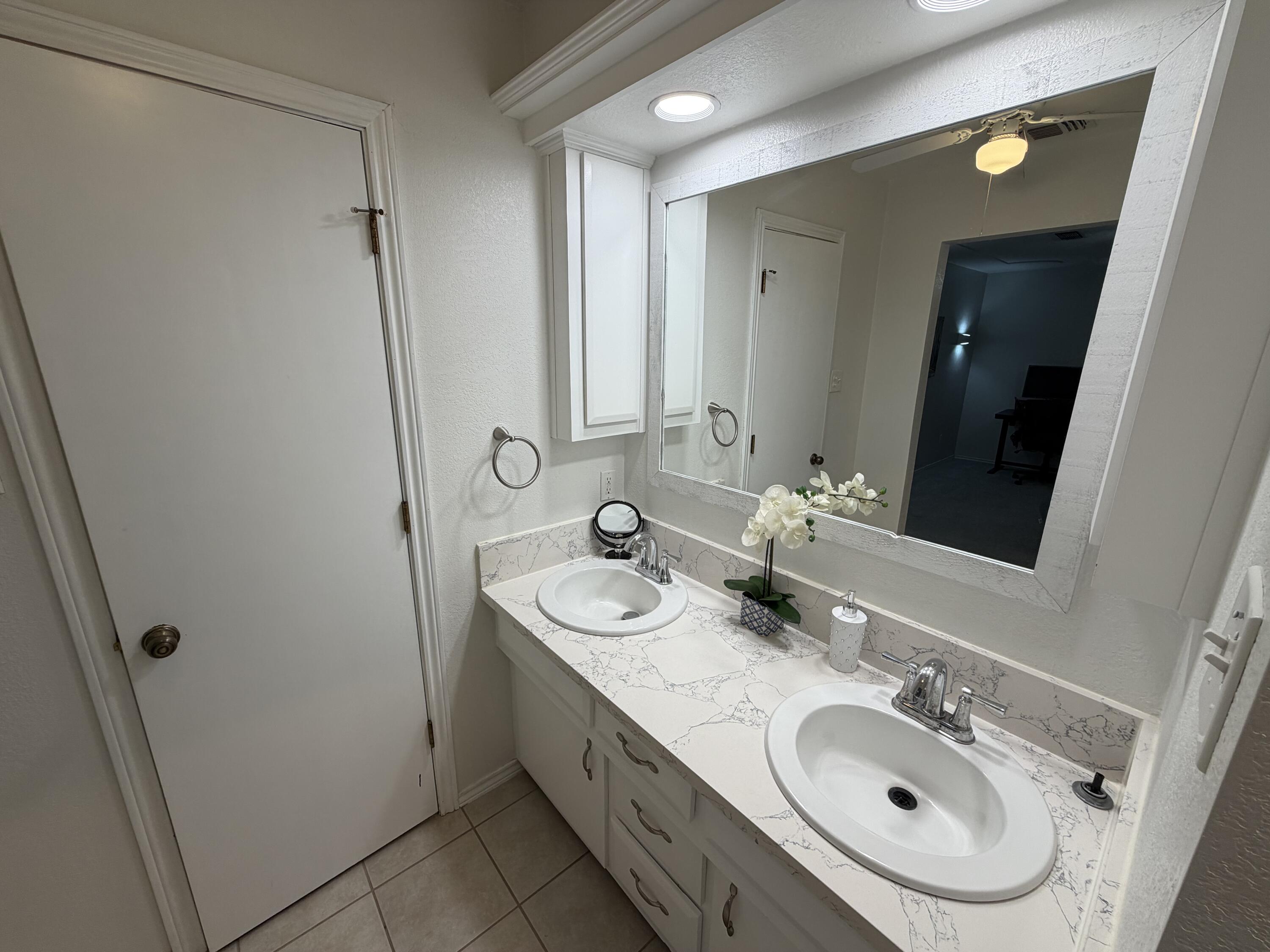 3236 94th Street Lubbock, TX 79423 - Photo 12 of 31 a bathroom with a sink and a mirror