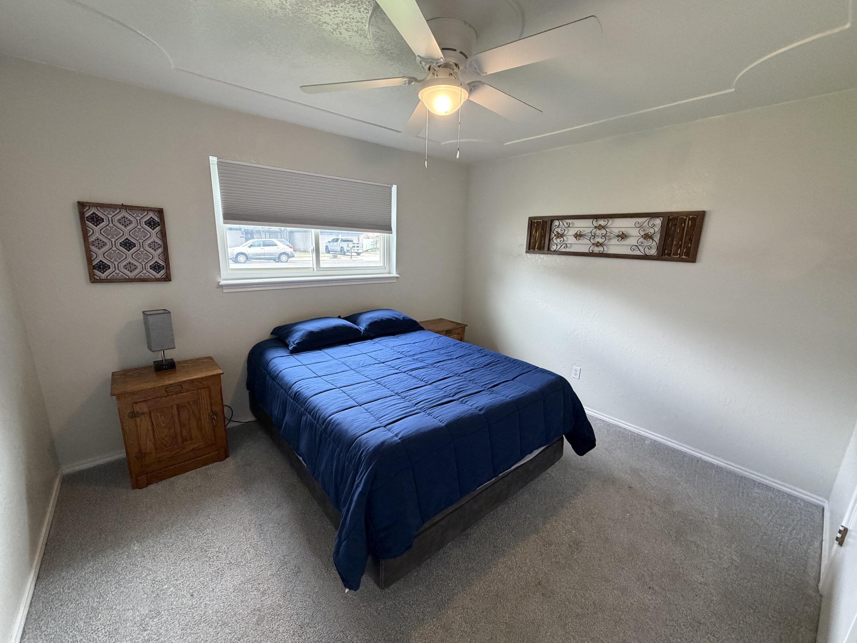 3236 94th Street Lubbock, TX 79423 - Photo 16 of 31 a bedroom with a bed and a chandelier