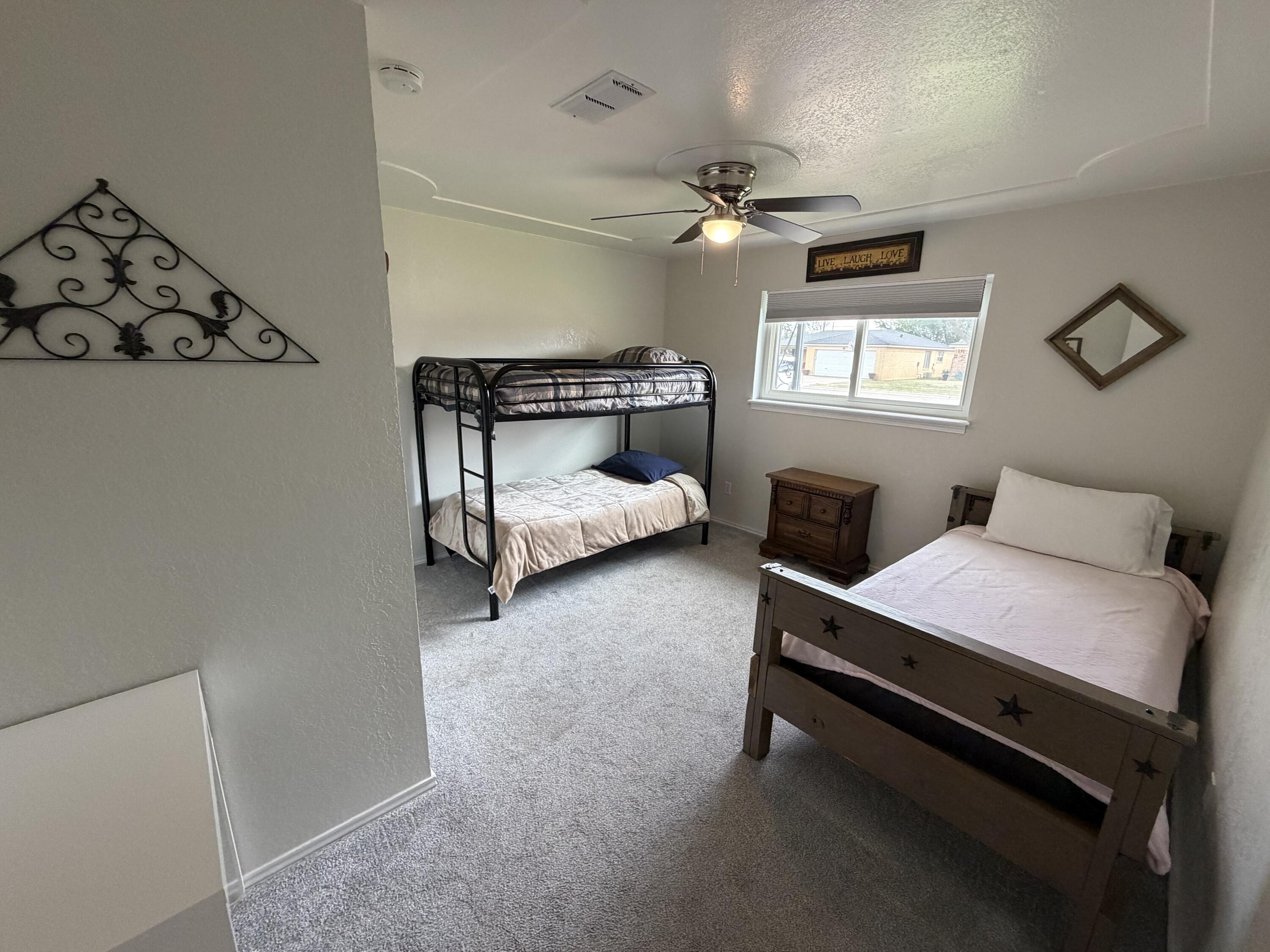 3236 94th Street Lubbock, TX 79423 - Photo 18 of 31 a bedroom with a bed and a chandelier