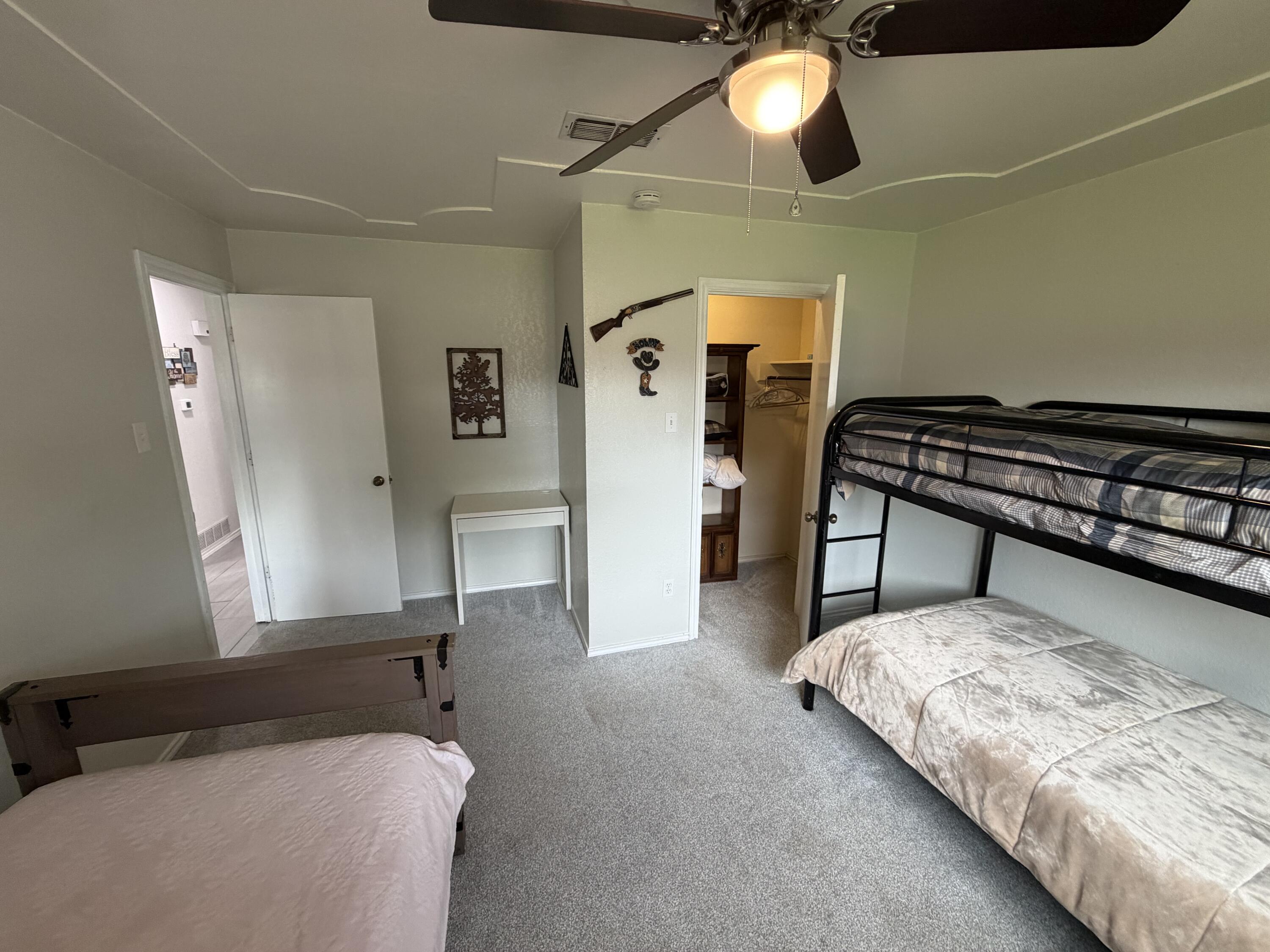 3236 94th Street Lubbock, TX 79423 - Photo 19 of 31 a bedroom with a bed and a chandelier
