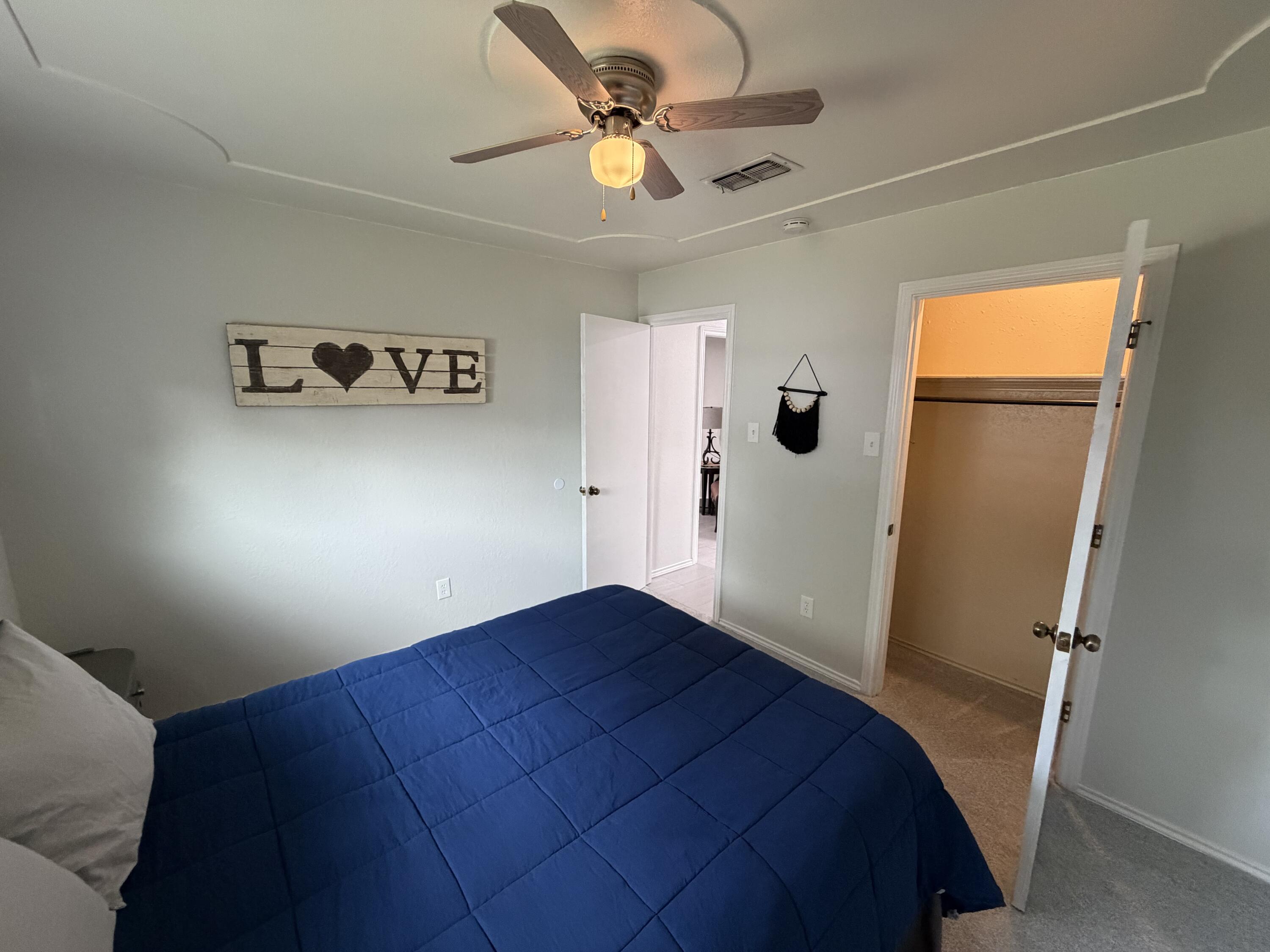 3236 94th Street Lubbock, TX 79423 - Photo 23 of 31 a bedroom with a bed and a chandelier fan