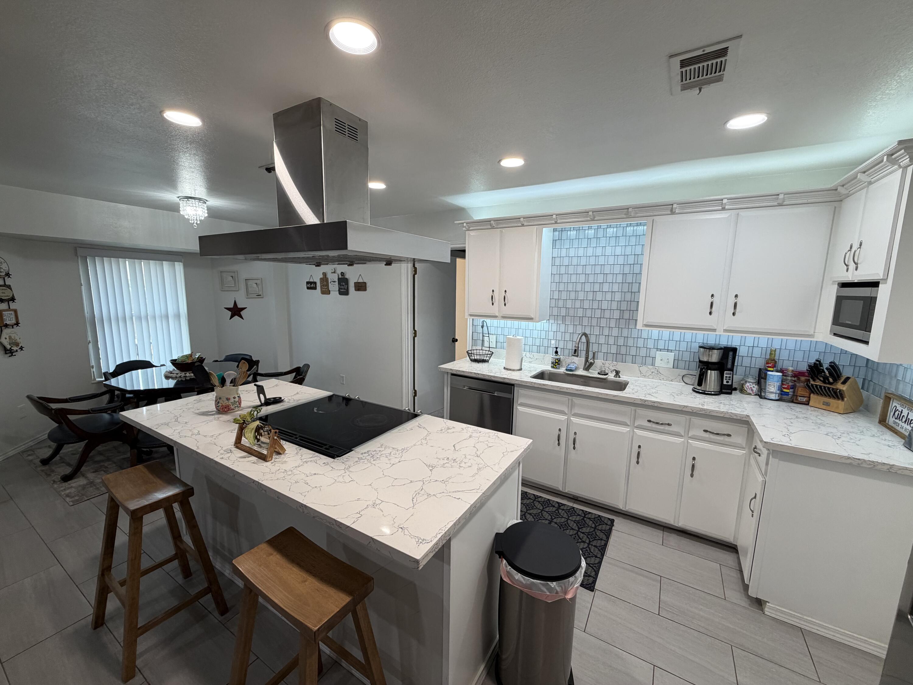3236 94th Street Lubbock, TX 79423 - Photo 7 of 31 a kitchen with a stove a table and chairs in it