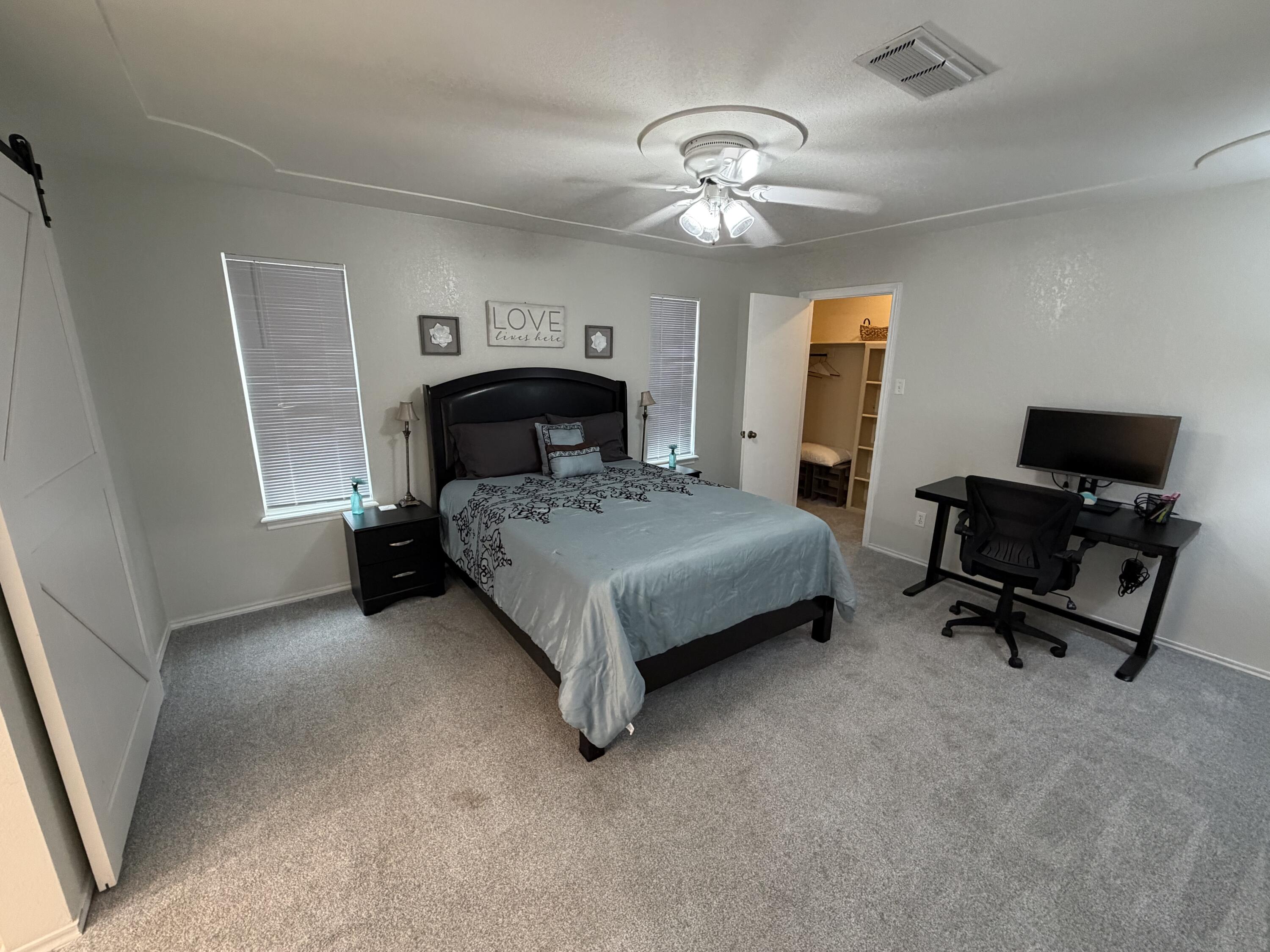 3236 94th Street Lubbock, TX 79423 - Photo 9 of 31 a bedroom with a bed and a chandelier