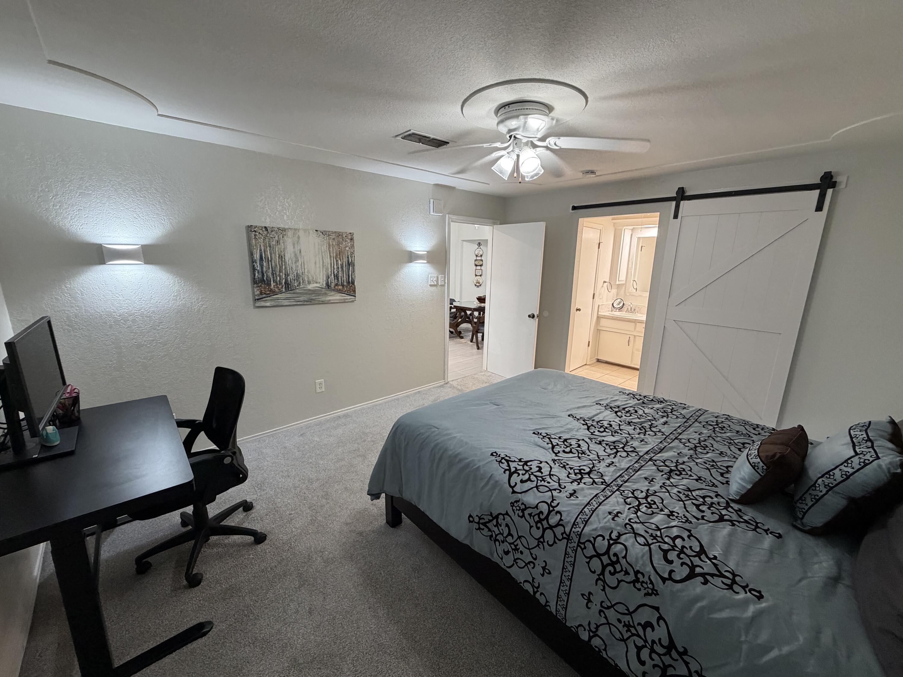3236 94th Street Lubbock, TX 79423 - Photo 10 of 31 a bedroom with a bed a desk and chair