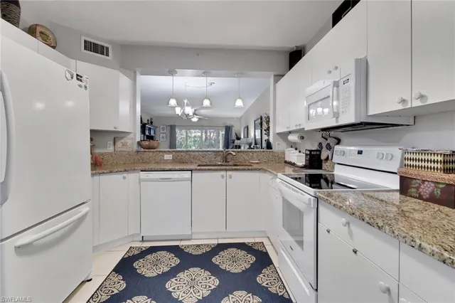 a kitchen with granite countertop a sink stove and cabinets
