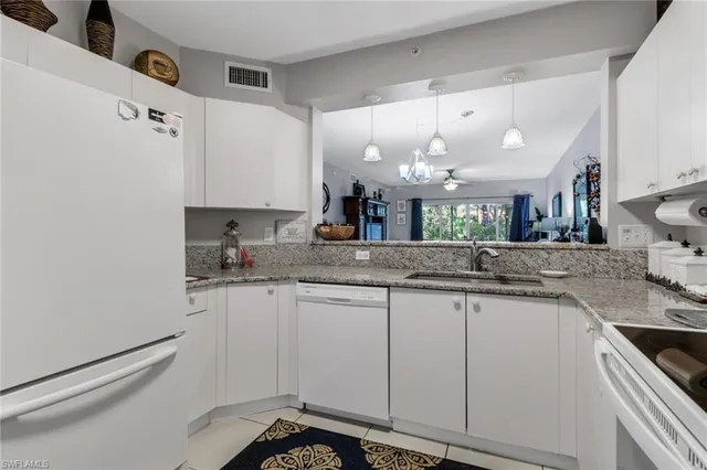 a kitchen with granite countertop a sink cabinets and stainless steel appliances