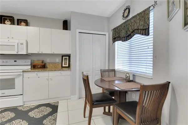 a kitchen with a table chairs and a window