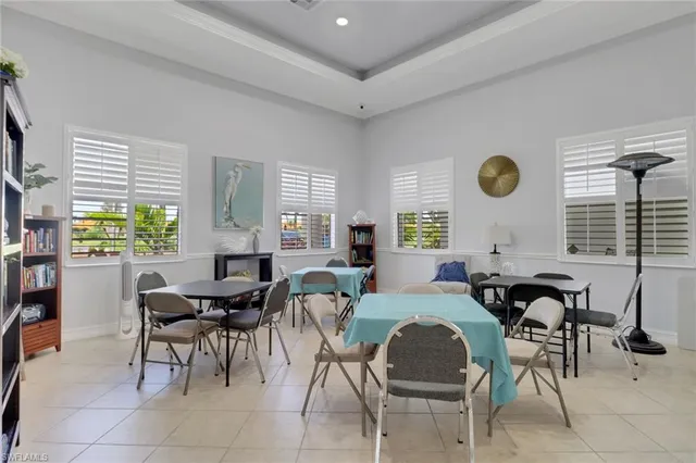 a living room with furniture a bookshelf and a window