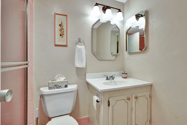 a bathroom with a toilet sink and mirror