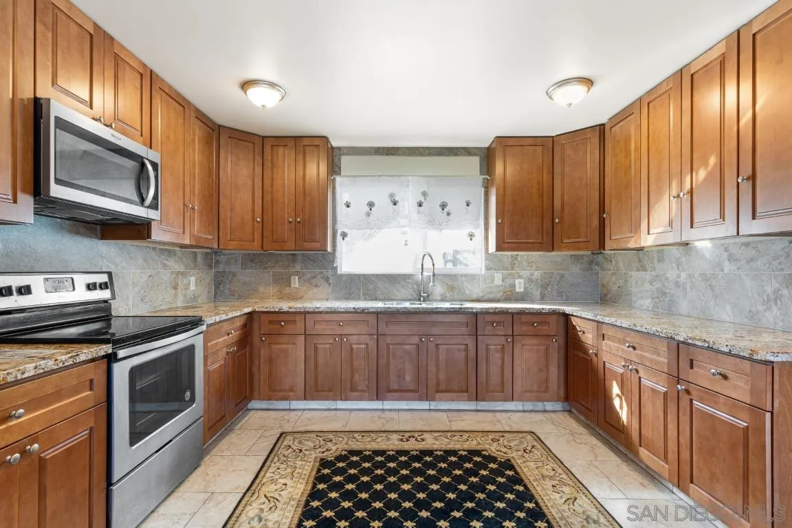732 Hamilton Lane Fallbrook, CA 92028 - Photo 20 of 54 a kitchen with stainless steel appliances granite countertop a stove a sink and a microwave