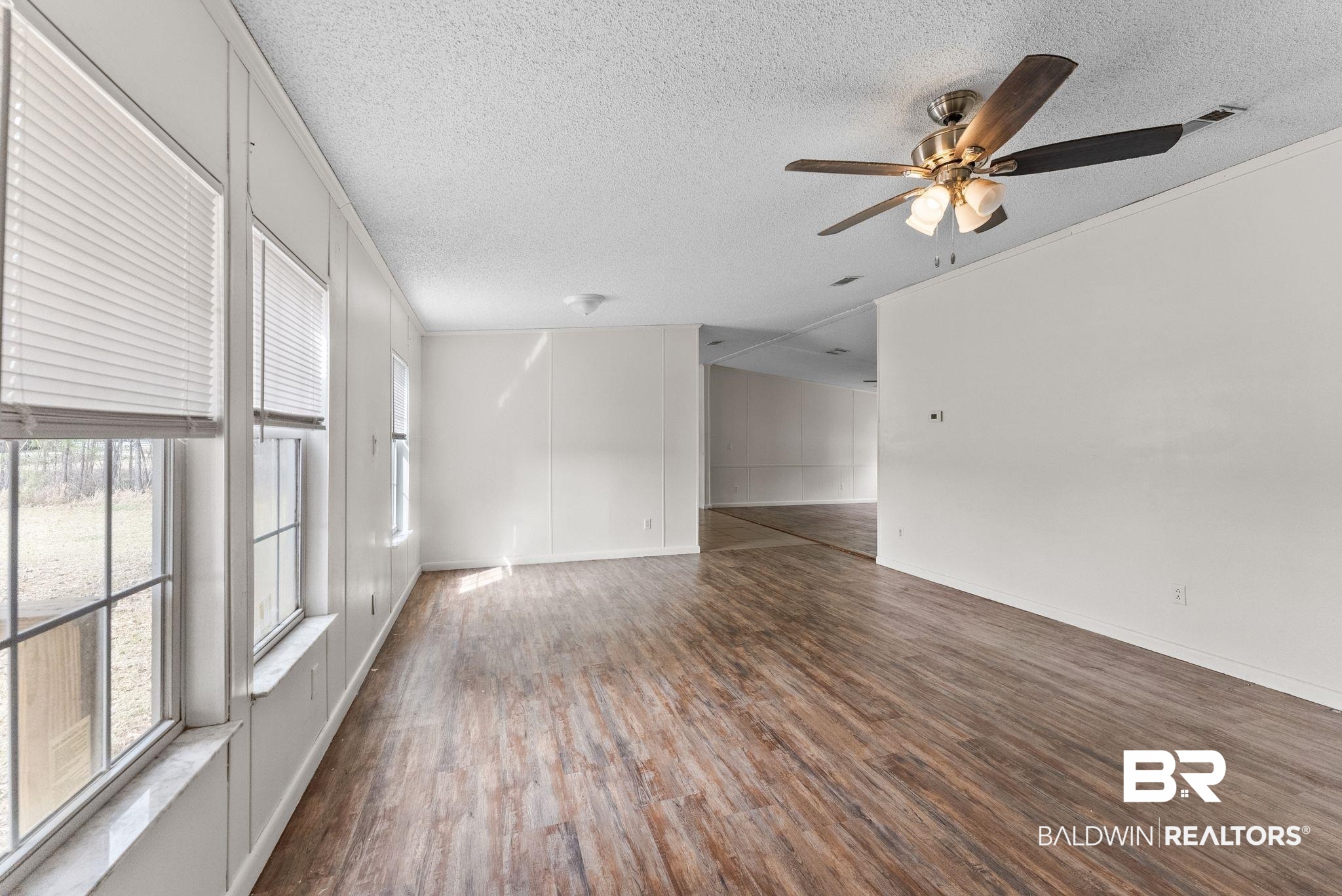 34904 Pine Road South Stapleton, AL 36578 - Photo 8 of 42 Empty room featuring dark wood finished floors, a textured ceiling, ceiling fan, and crown molding