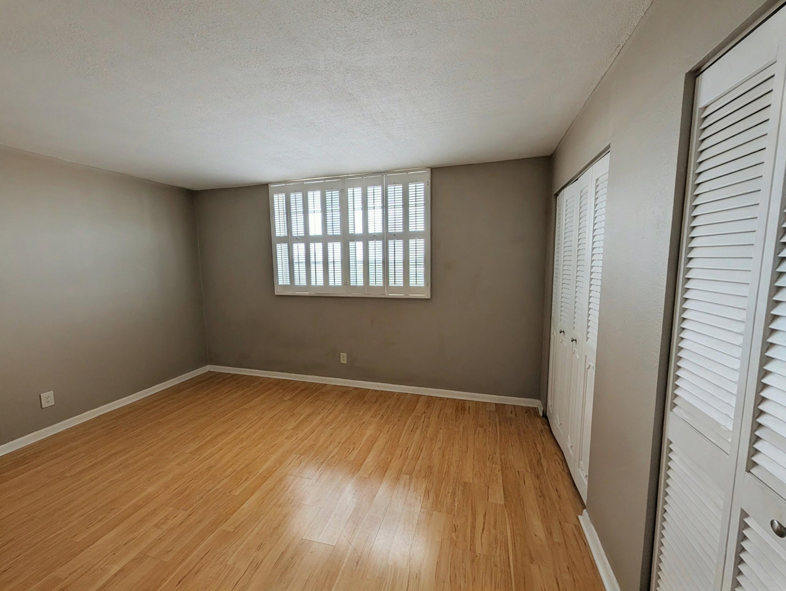 5700 Northwest 2nd Avenue, Unit 509 Boca Raton, FL 33487 - Photo 12 of 20 an empty room with wooden floor and windows