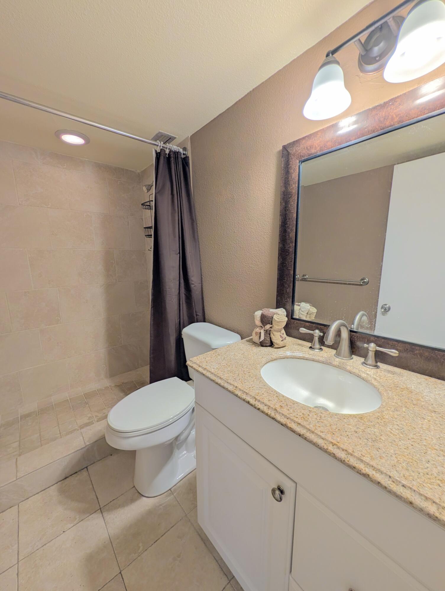 5700 Northwest 2nd Avenue, Unit 509 Boca Raton, FL 33487 - Photo 13 of 20 a bathroom with a granite countertop sink toilet and a mirror