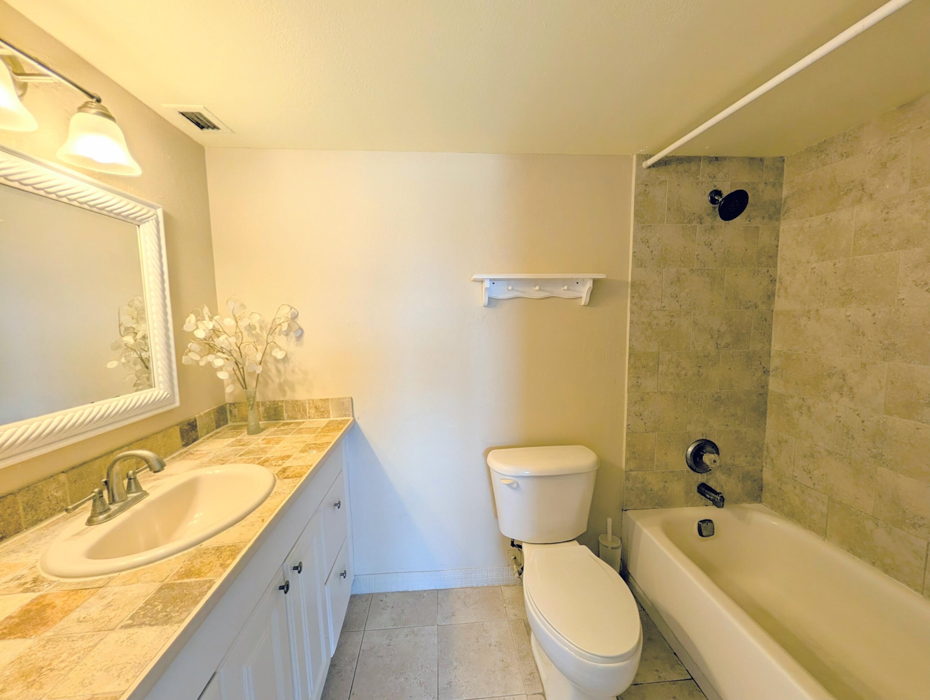 5700 Northwest 2nd Avenue, Unit 509 Boca Raton, FL 33487 - Photo 10 of 20 a bathroom with a granite countertop toilet a sink and a bathtub