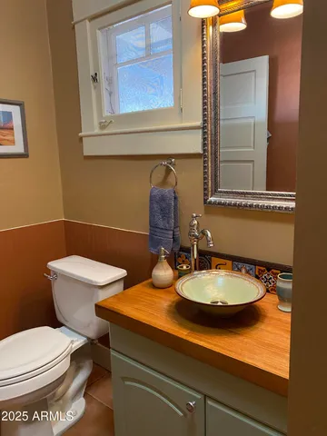 a bathroom with a toilet a sink and mirror
