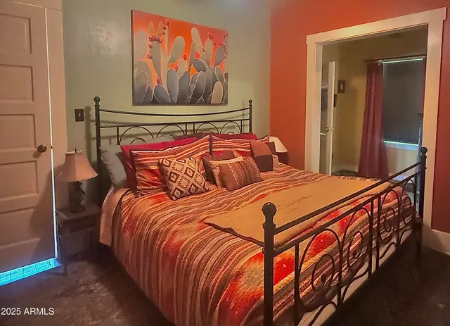 a bedroom with a bed and painting on the wall