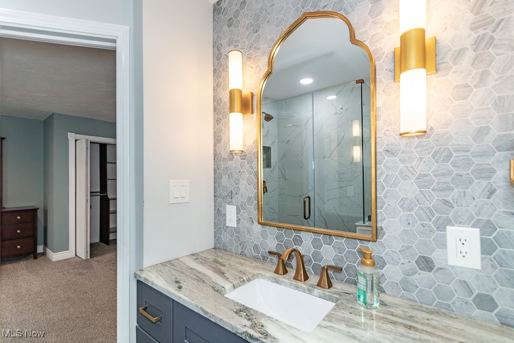 38856 Johnnycake Ridge Road Willoughby, OH 44094 - Photo 11 of 49 Primary bathroom with custom vanity, marble backsplash and counters and matte gold finishes.