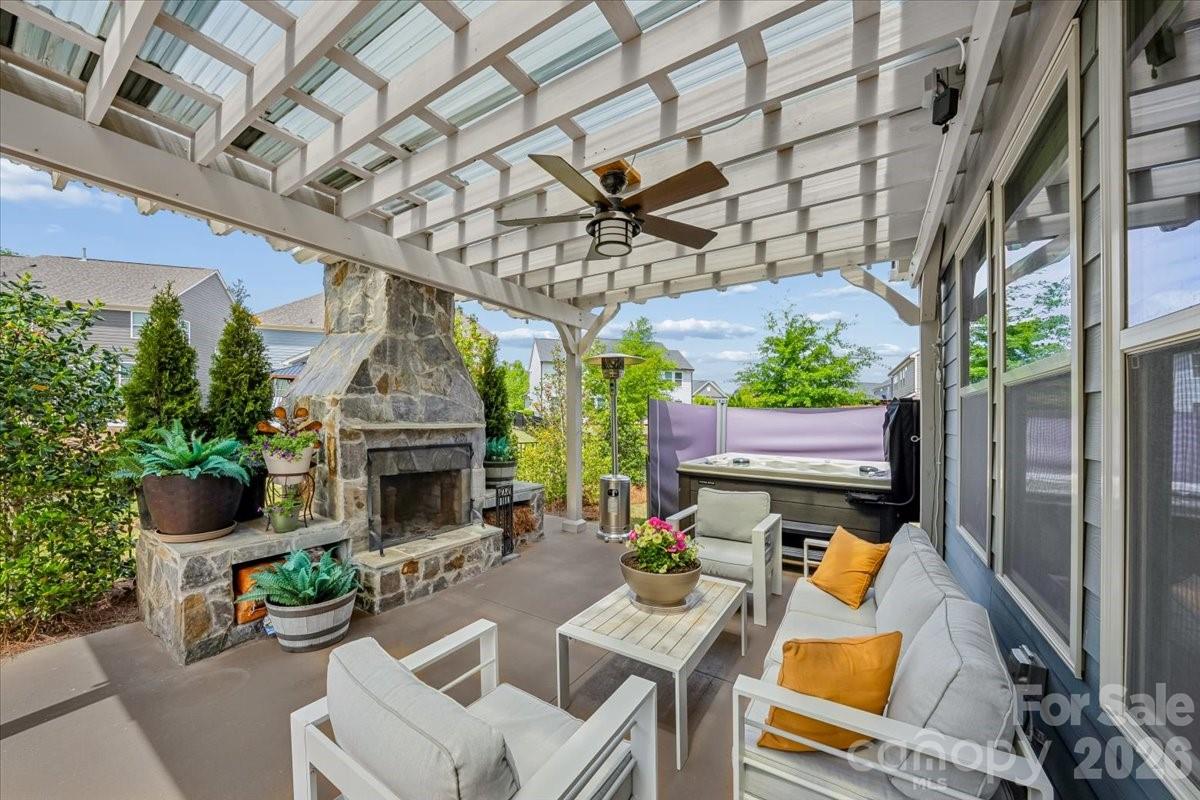 1135 Weir Court Fort Mill, SC 29708 - Photo 8 of 44 a view of a patio with couches table and chairs potted plants with wooden floor and a fireplace