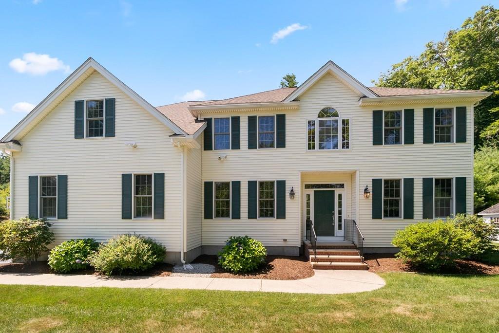 a front view of a house with yard and green space