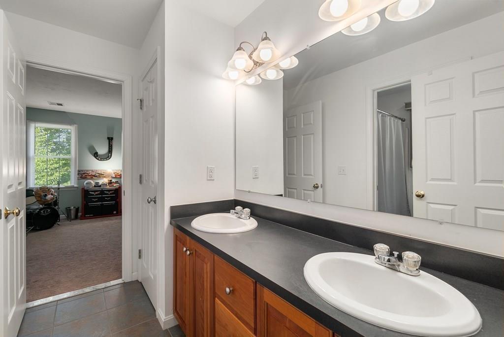 300 Crownshield Avenue Uxbridge, MA 01569 - Photo 22 of 29 a en suite bathroom with a double vanity sink and a mirror