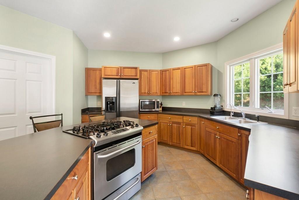 300 Crownshield Avenue Uxbridge, MA 01569 - Photo 7 of 29 a kitchen with stainless steel appliances granite countertop a stove a sink and a microwave