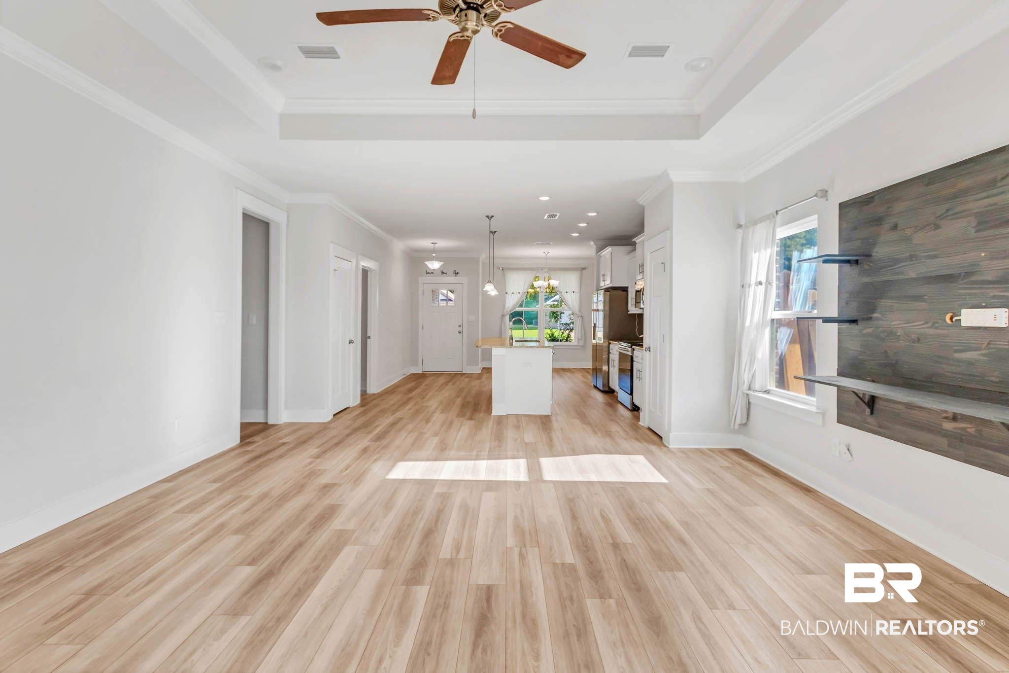 16461 Prado Loop Loxley, AL 36551 - Photo 16 of 78 Unfurnished living room with a raised ceiling, ornamental molding, light wood-style flooring, recessed lighting, and ceiling fan