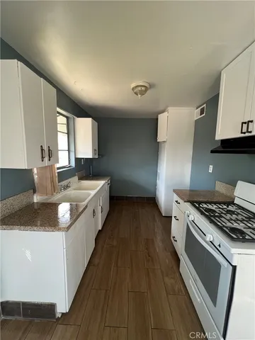 a kitchen with stainless steel appliances granite countertop a sink stove and cabinets