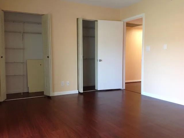 an empty room with wooden floor and closet