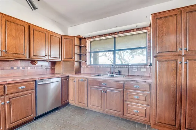 a kitchen with stainless steel appliances granite countertop a refrigerator and wooden cabinets