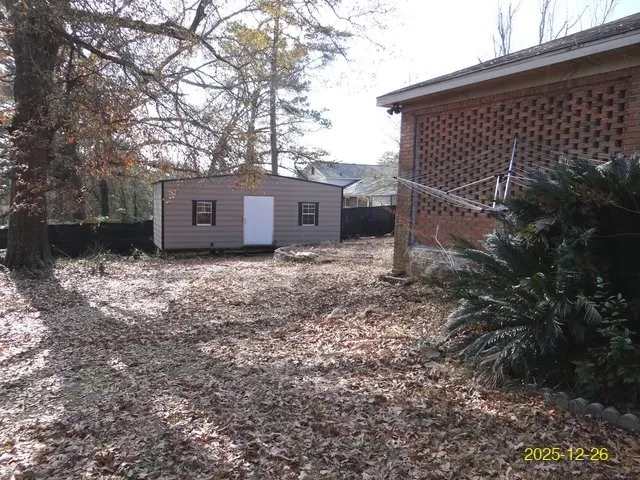 a backyard of a house with large trees and barbeque oven