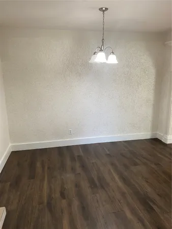 a room with wooden floor and ceiling fan
