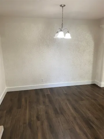 a room with wooden floor and ceiling fan