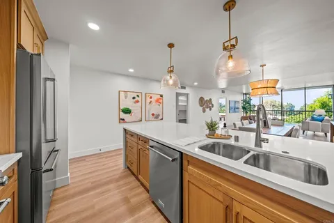 a kitchen with stainless steel appliances granite countertop a refrigerator a stove and a wooden floors