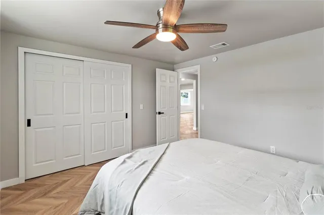 a bedroom with a bed and a ceiling fan