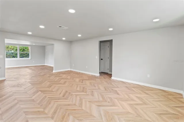 a view of an empty room with wooden floor