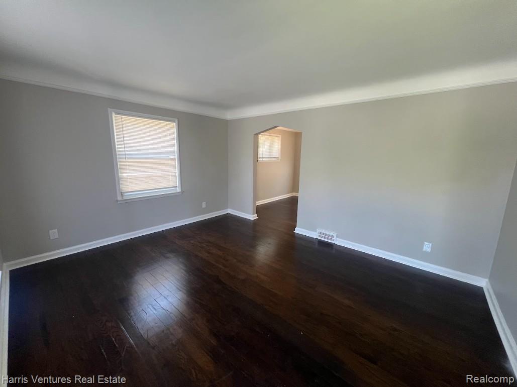22148 Moross Road Grosse Pointe, MI 48236 - Photo 6 of 16 Spacious interior featuring dark wood-finish flooring, light neutral wall paint, white baseboards, and white window trim