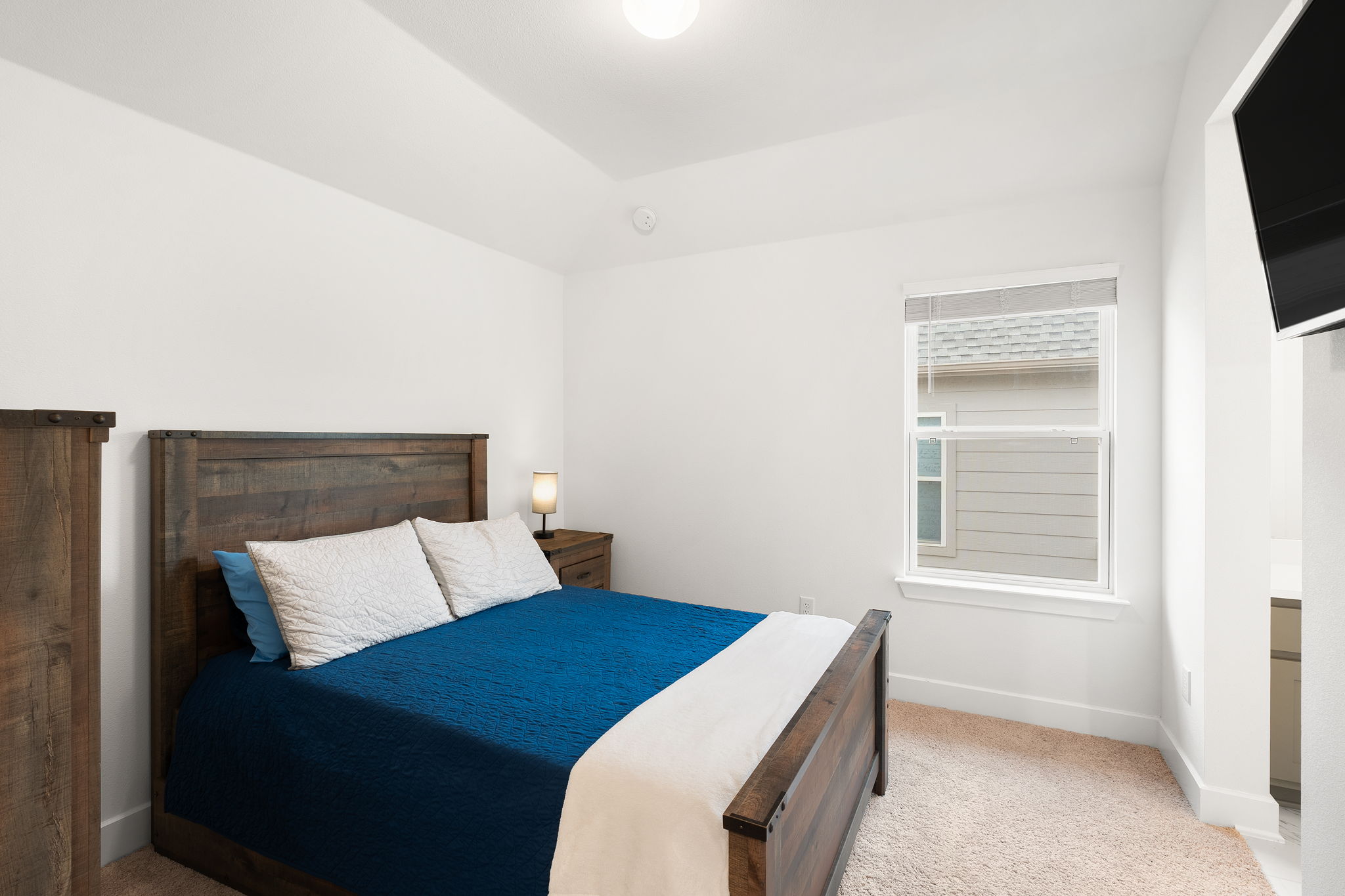 515 Watershield Cove Georgetown, TX 78633 - Photo 29 of 40 A cozy bedroom with a vaulted ceiling and a window offering natural light.