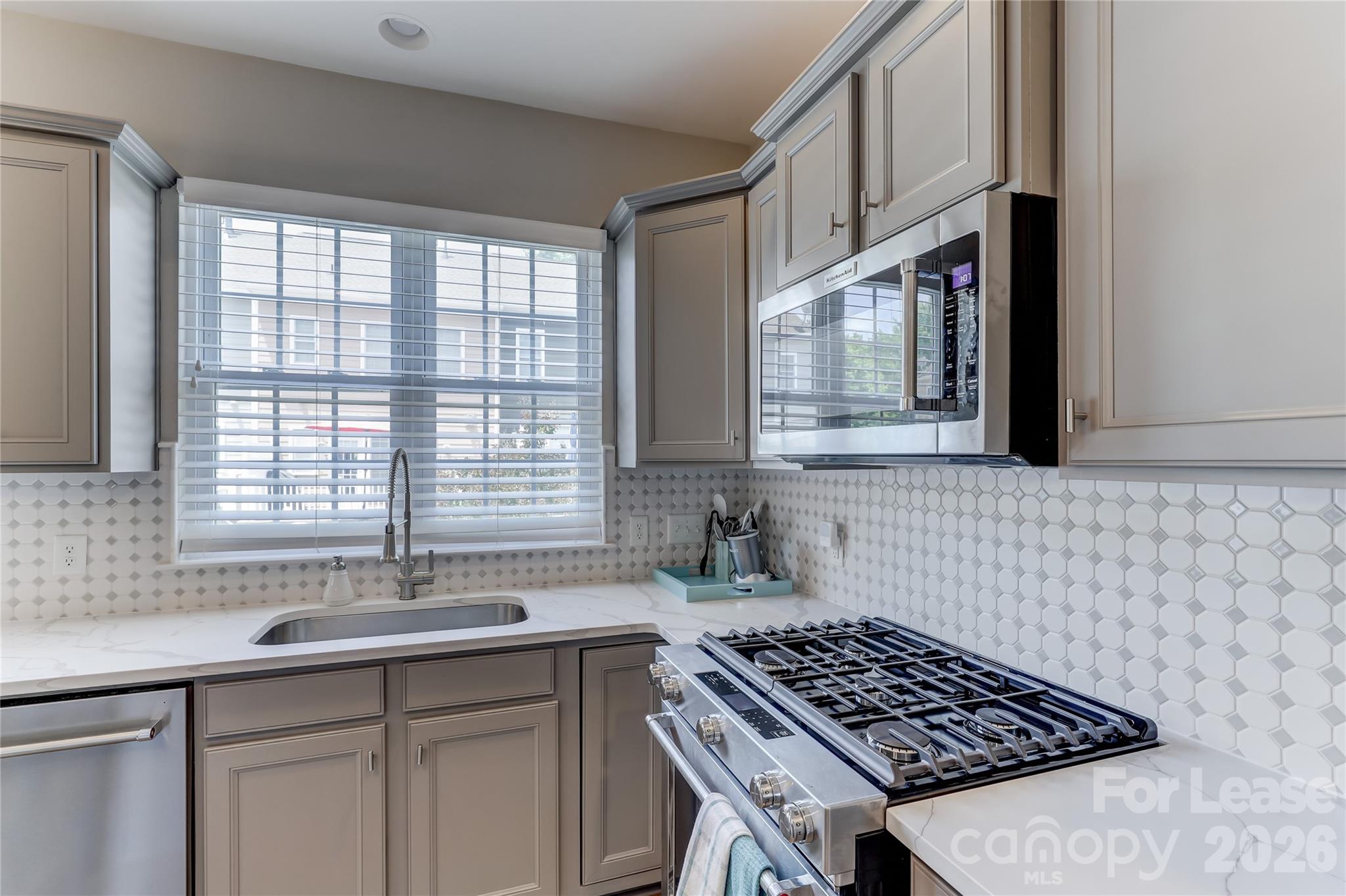 905 Lyndley Drive Fort Mill, SC 29708 - Photo 19 of 42 a kitchen with stainless steel appliances a sink a stove and a window