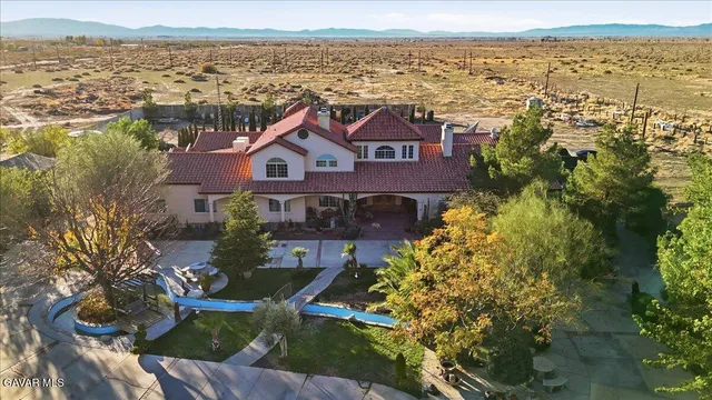 a view of swimming pool with outdoor seating and trees in the background