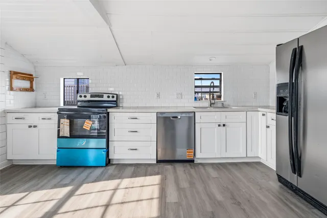 a kitchen with stainless steel appliances a stove top oven and refrigerator