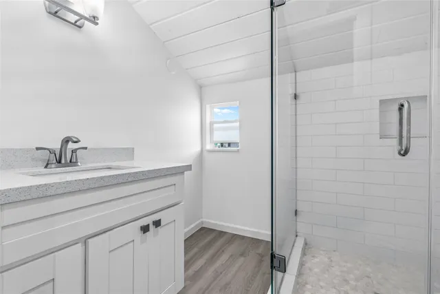 a bathroom with a shower sink and mirror