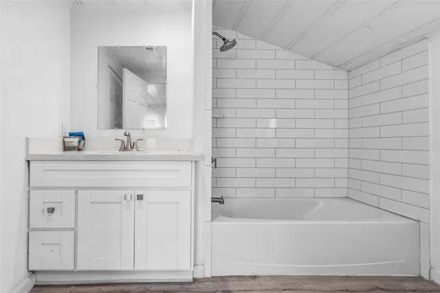 a bathroom with a bathtub a sink and a mirror