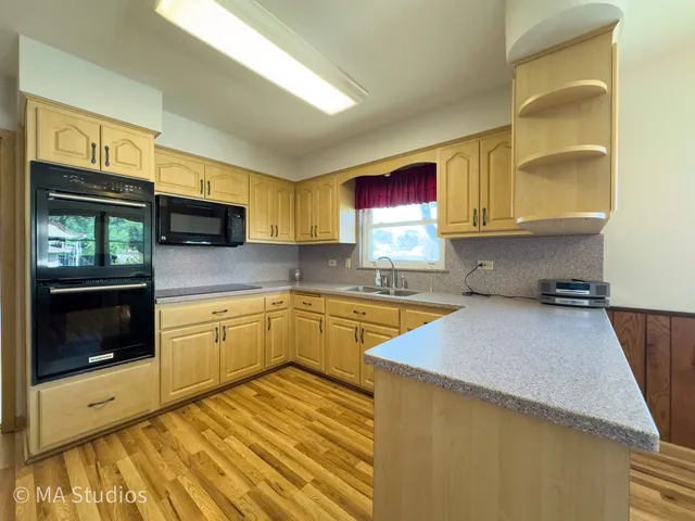 a kitchen with stainless steel appliances granite countertop a stove a sink and a microwave