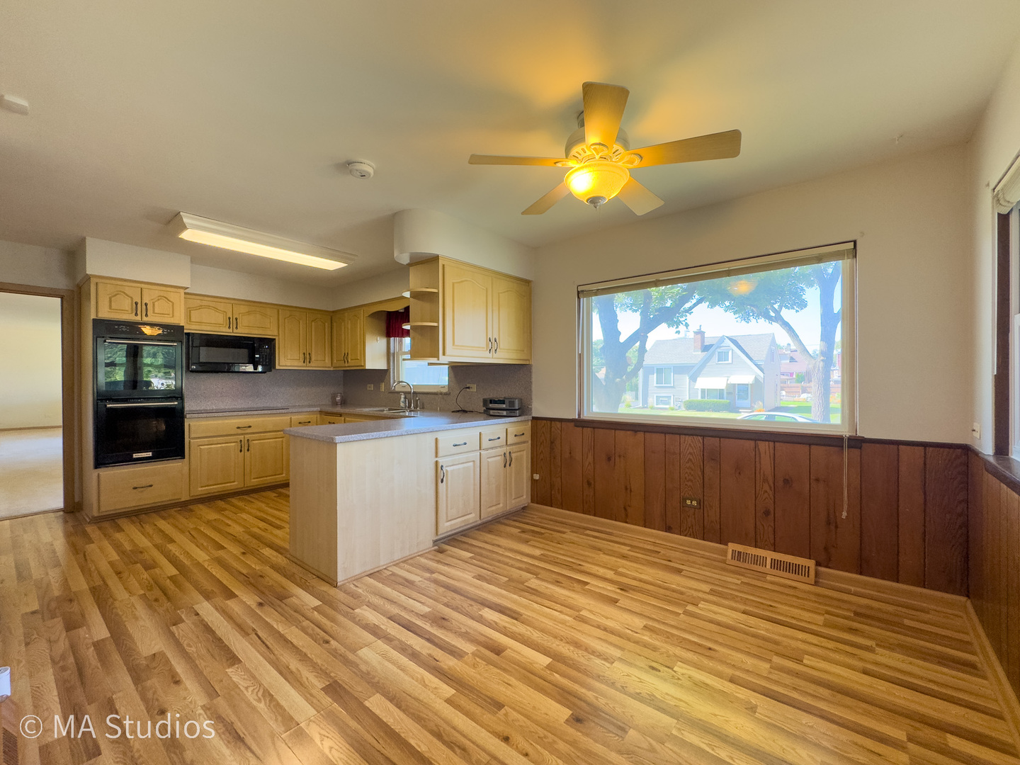 8636 40th Street Lyons, IL 60534 - Photo 13 of 50 a kitchen with stainless steel appliances kitchen island granite countertop a refrigerator a stove top oven and a sink with wooden floor