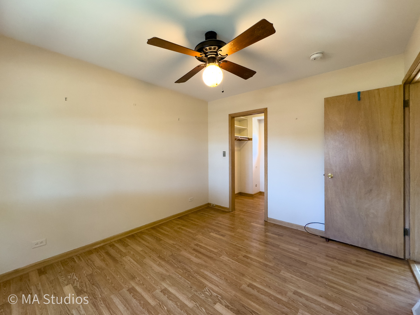 8636 40th Street Lyons, IL 60534 - Photo 21 of 50 a view of an empty room with wooden floor and a ceiling fan