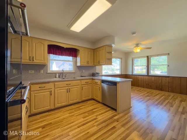 a kitchen with stainless steel appliances granite countertop a stove a sink and a microwave