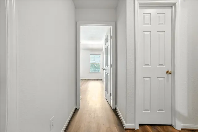a view of a hallway with wooden floor